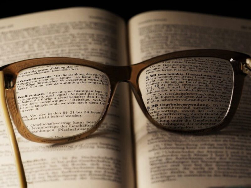 Ein aufgeschlagenes Gesetzbuch, auf dem eine Brille liegt